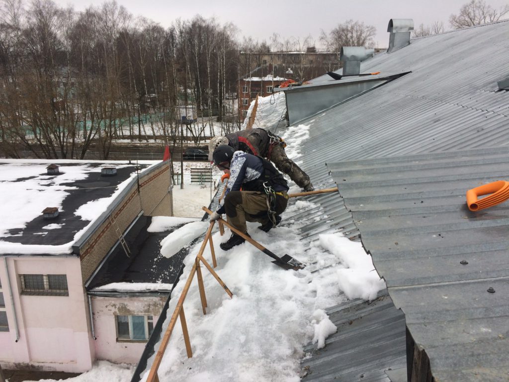 Уборка снега с крыши верхолазами