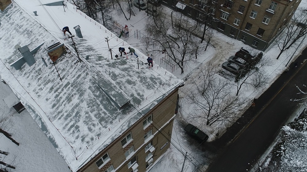 Уборка снега с крыши верхолазами