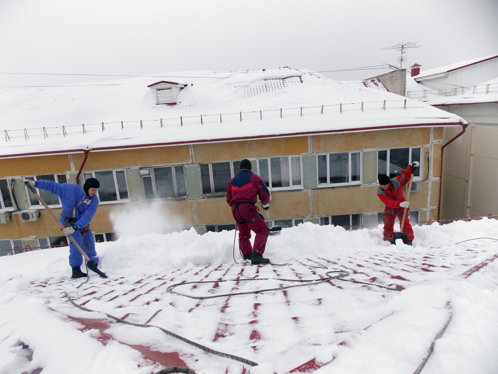Уборка снега с кровли высотного дома